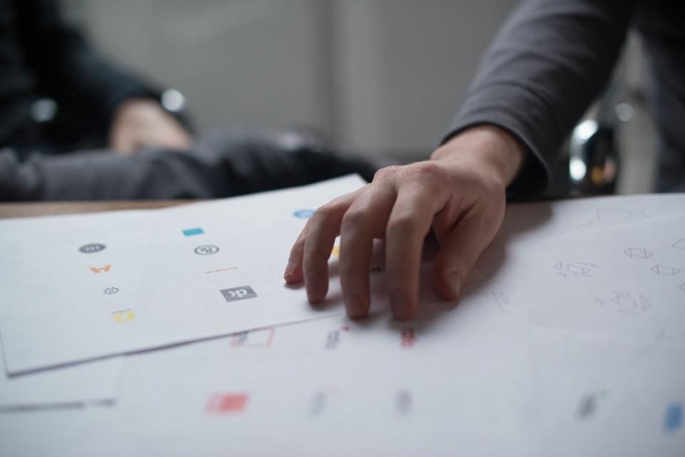 Hand resting on design sketches