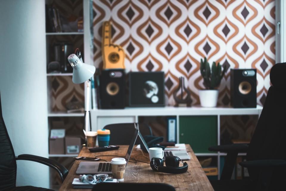Retro home office with speakers and patterned wallpaper
