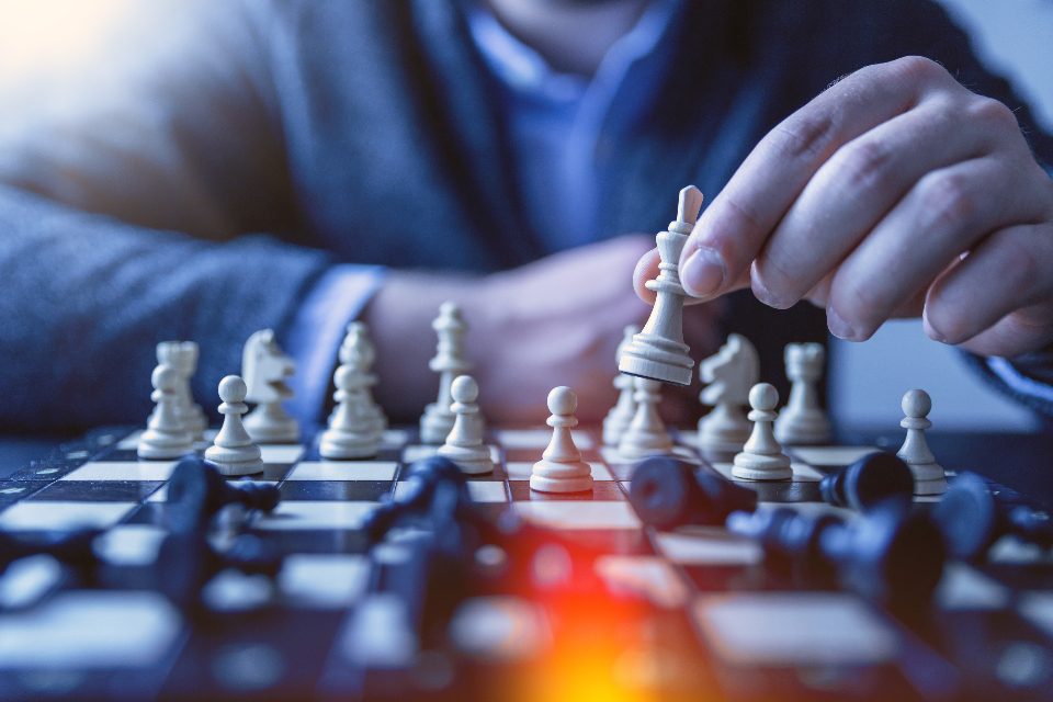 Hand moving a chess piece on a board