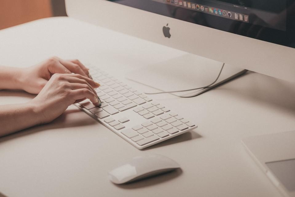 Hands typing on a computer keyboard
