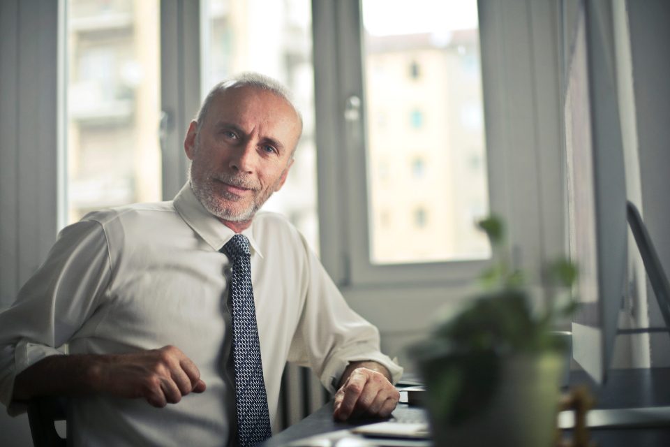 Smiling older businessman at his desk