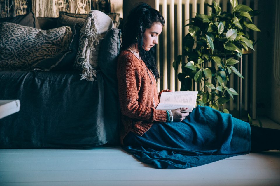 Woman reading a book by a window