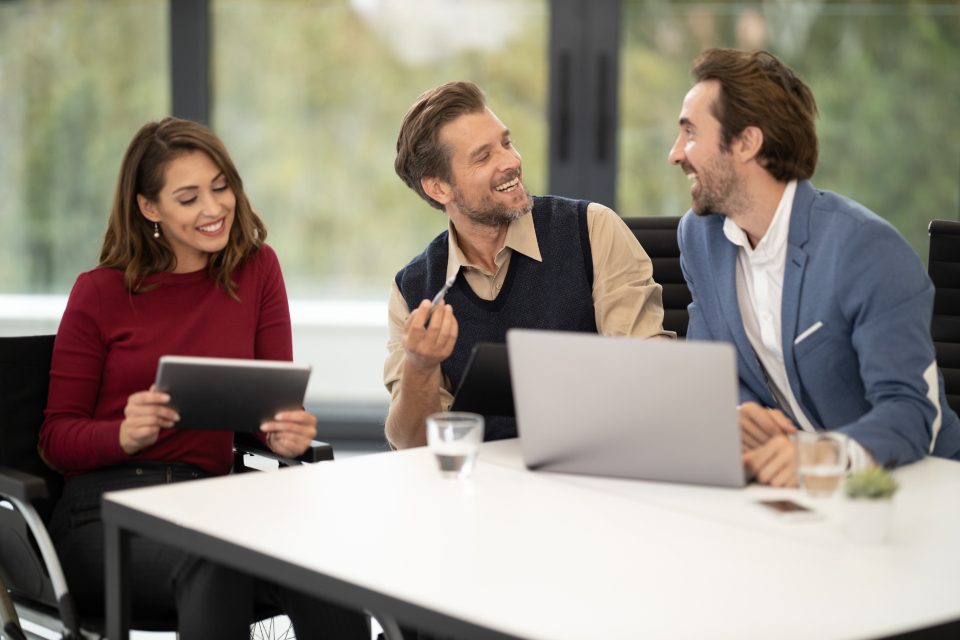 Woman with a tablet talking to two colleagues