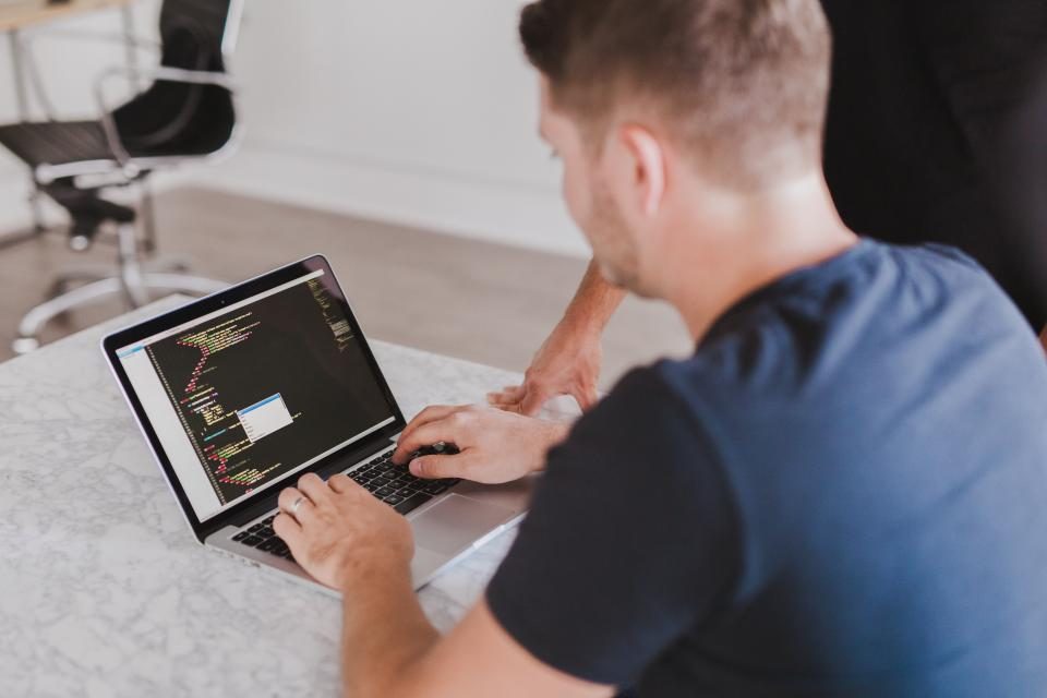 Man working on a laptop showing code