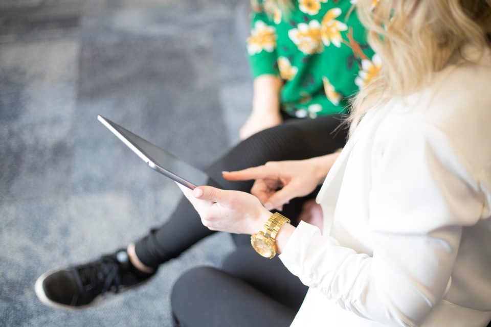 Two colleagues discussing something on a tablet