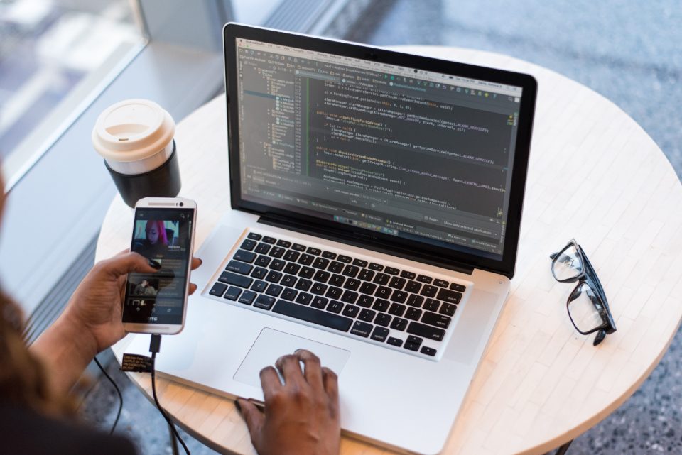 Laptop with code, a phone and coffee