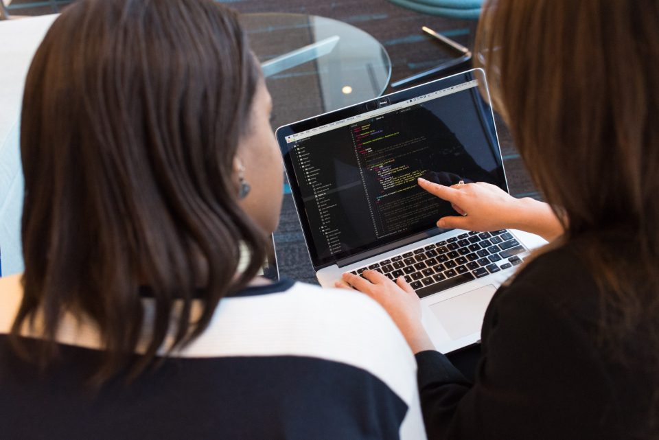 Two women looking at a laptop together