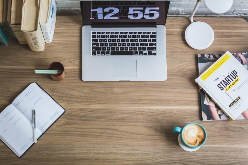 Laptop, notebook and coffee on a wooden desk