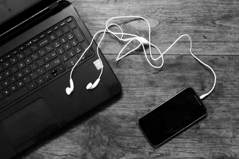 Laptop keyboard, earphones and a phone