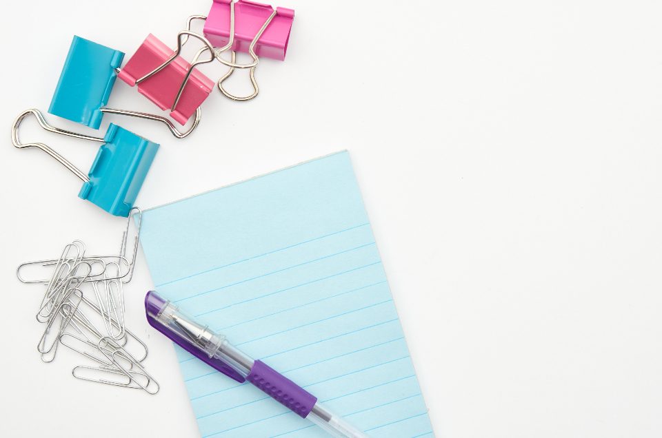 Binder clips and notepad on a desk