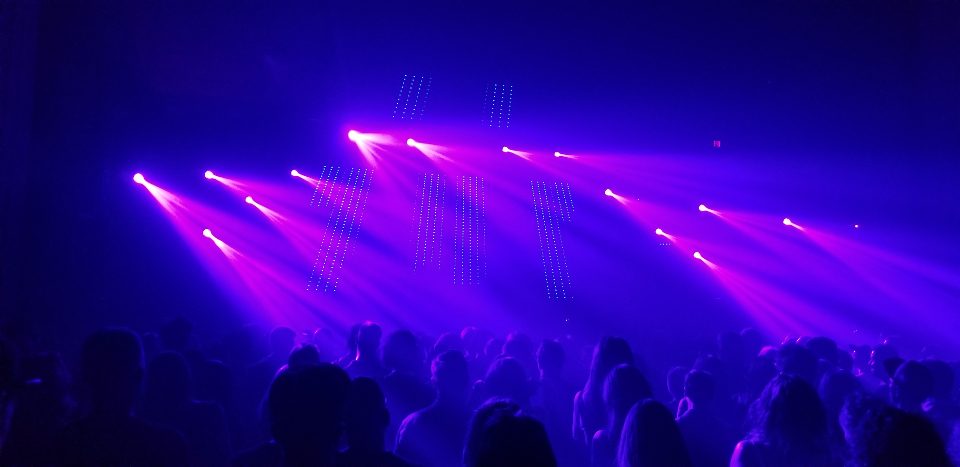 Audience under purple stage lights at a live event