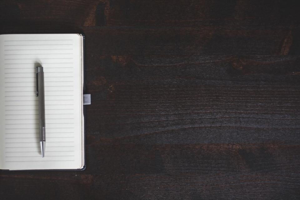 Notebook and pen on a dark desk