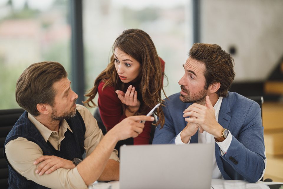 Colleague explaining an idea to two coworkers at a laptop