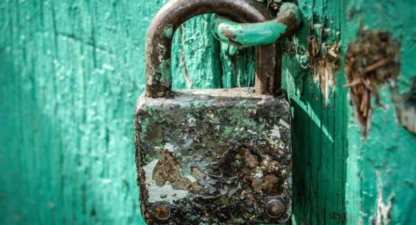 Rusty padlock on a green wooden door