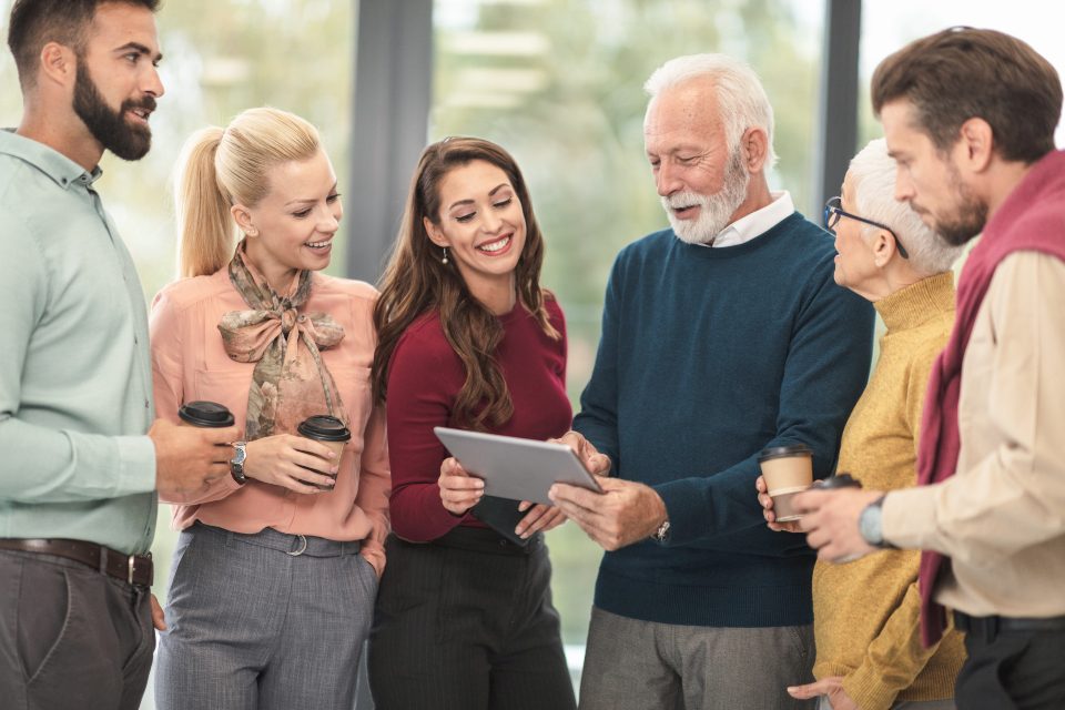 Colleagues of different ages looking at a tablet