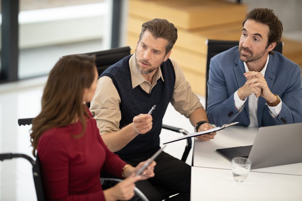 Three colleagues discussing at a table