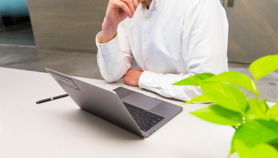 Man working at a laptop beside a plant
