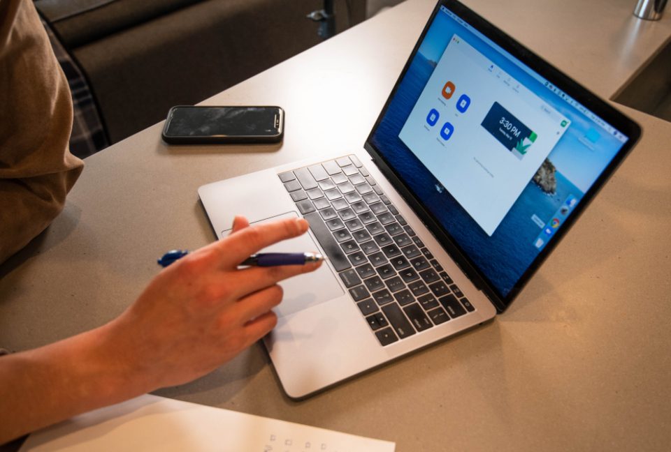 Hand pointing at a laptop screen
