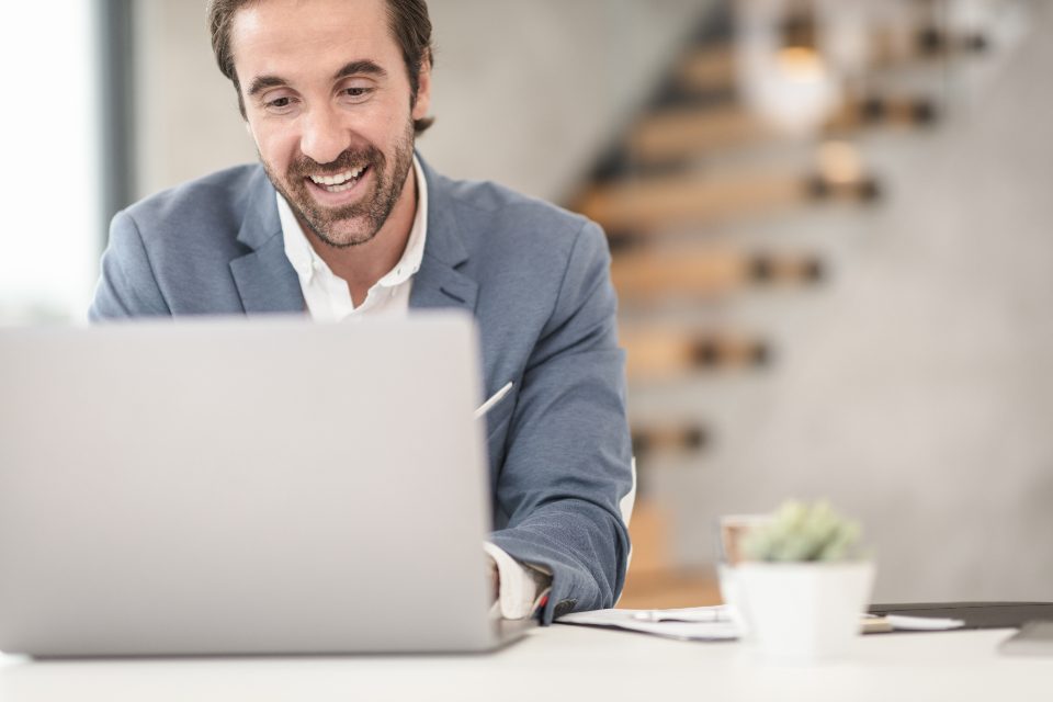 Smiling businessman working on a laptop