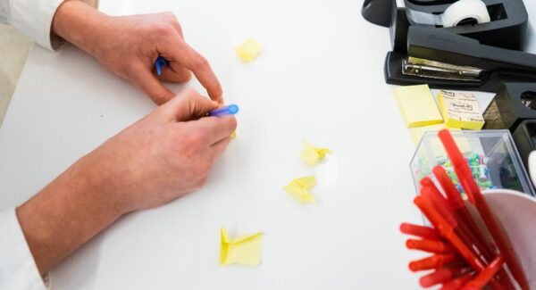 Hands arranging sticky notes on a desk