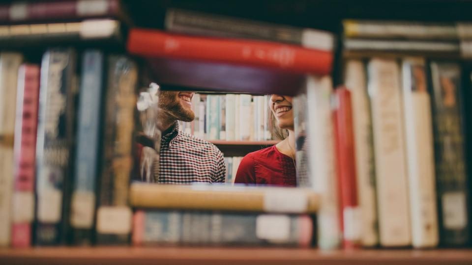 Person between library bookshelves