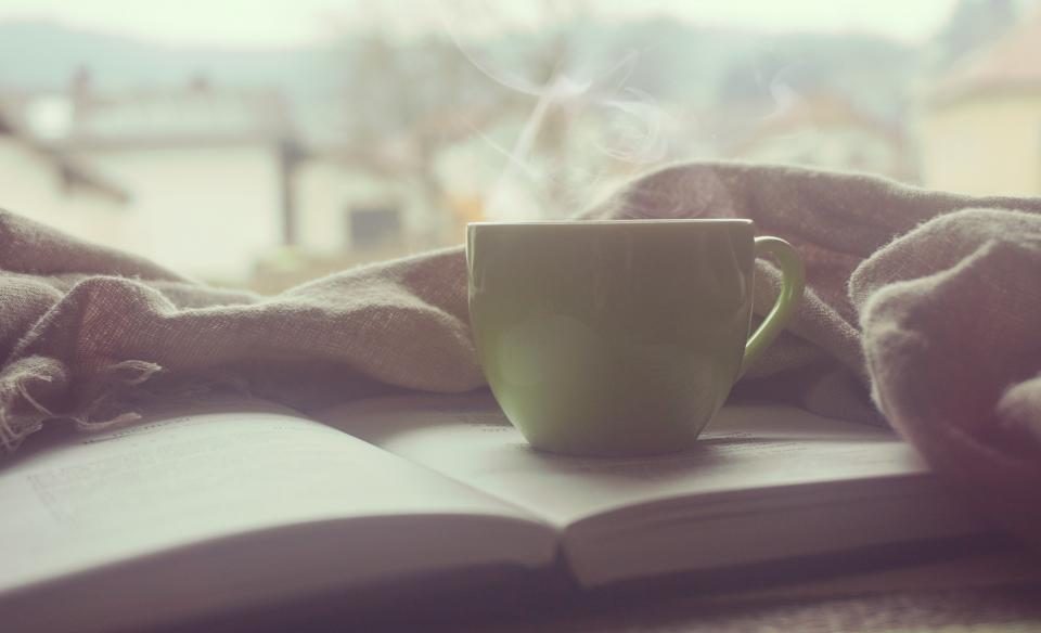 Cup of tea on an open book by a window