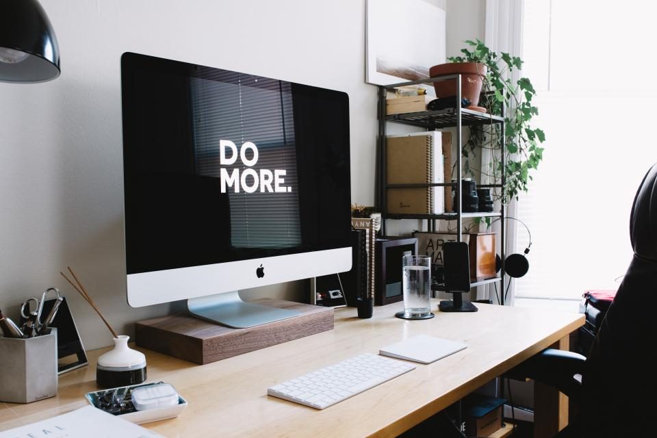 Desktop computer on a desk with plants and shelves