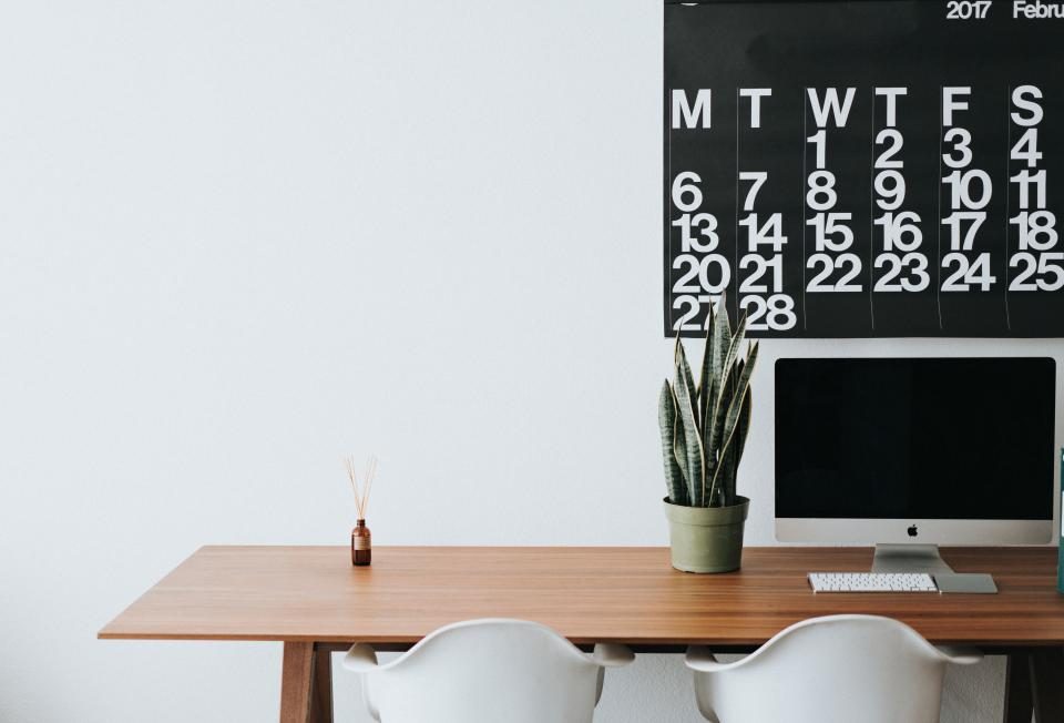 Desk with a computer and a wall calendar