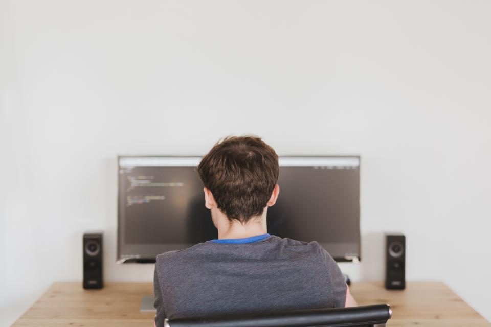 Man coding at a desktop computer
