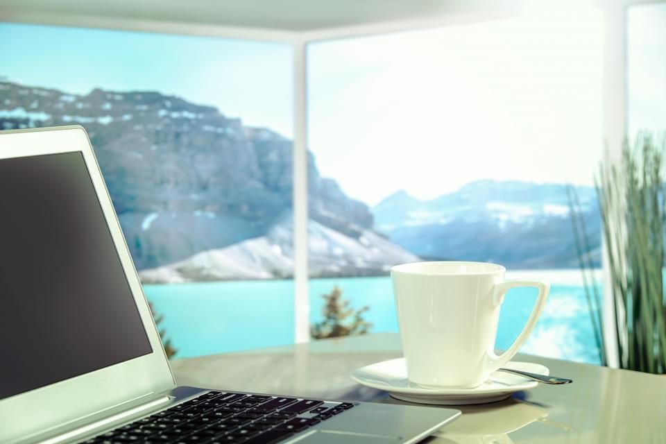 Laptop on a table by a window with a view
