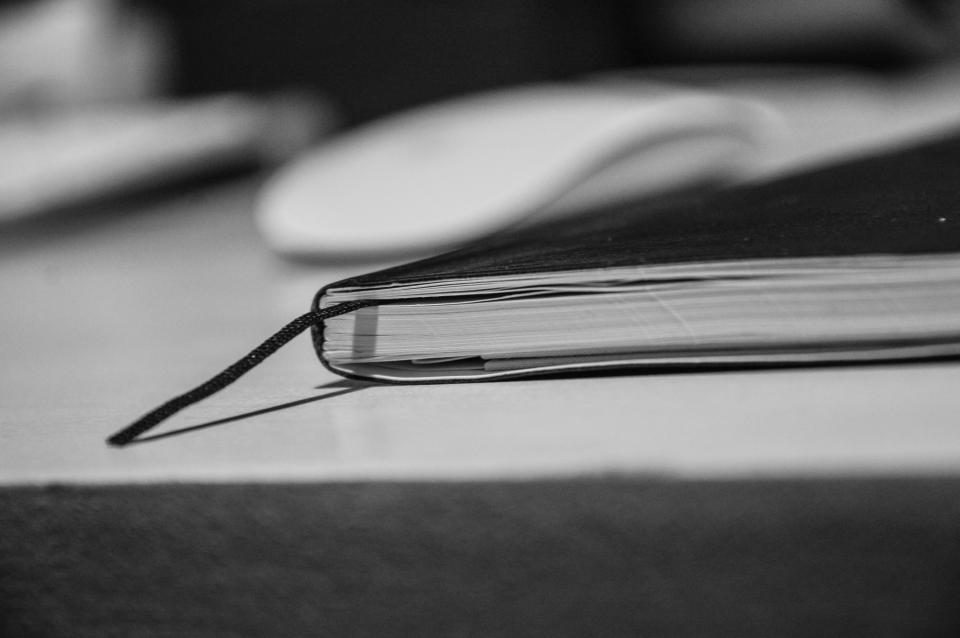 Black-and-white notebook and pen on a desk