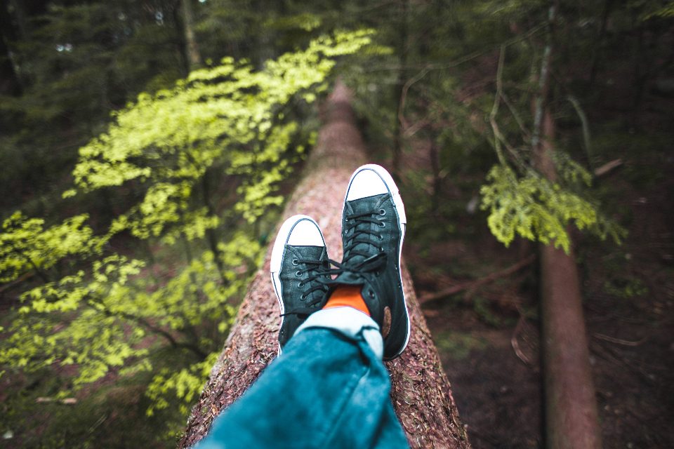 Feet resting on a log in a forest