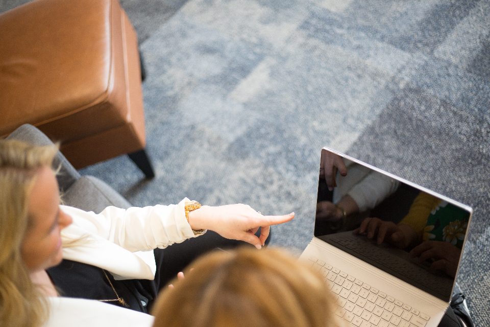 Colleagues pointing at a laptop screen in a meeting