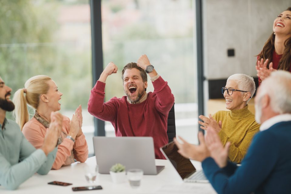 Team celebrating around a meeting table