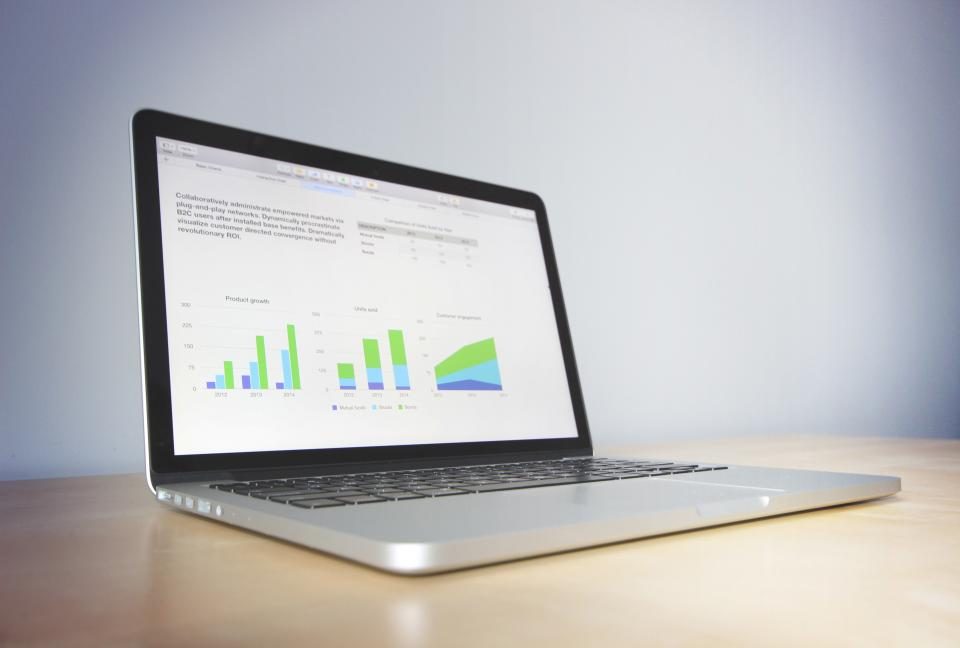 Laptop showing charts on a white desk