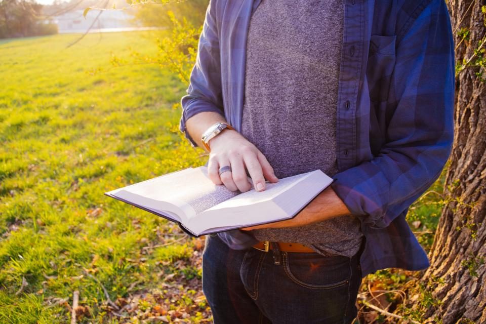 Man reading a book outdoors