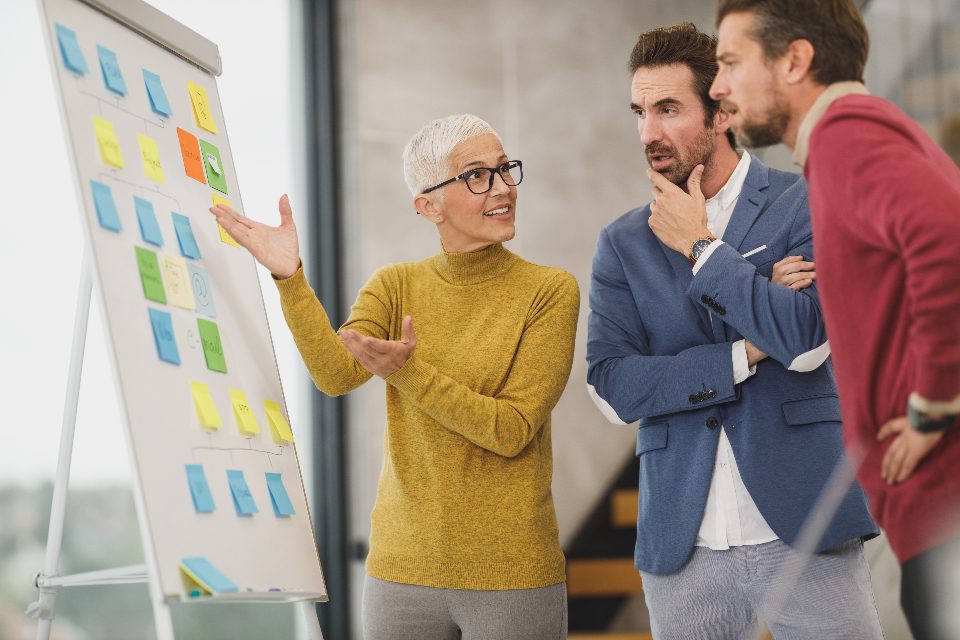 Woman presenting at a flipchart with sticky notes