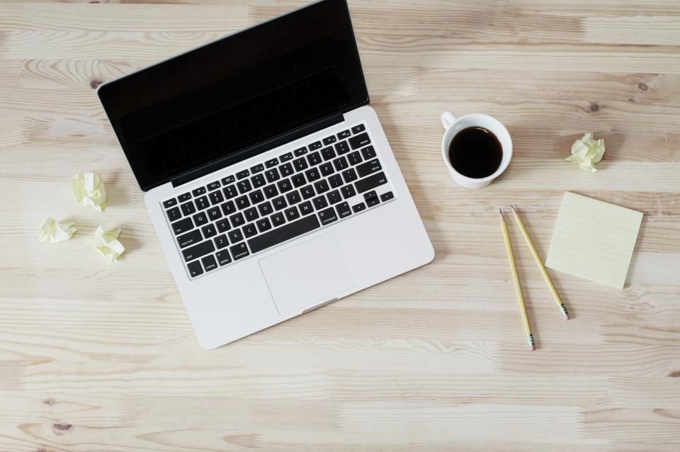Laptop and coffee on a desk seen from above