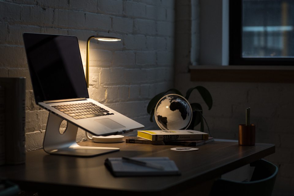 Laptop on a stand at a dark desk